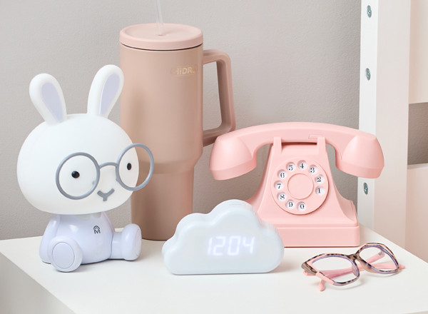 Back-to-school electronics: vintage pink telephone headset, bunny lamp, and whilte cloud-shaped digital clock.