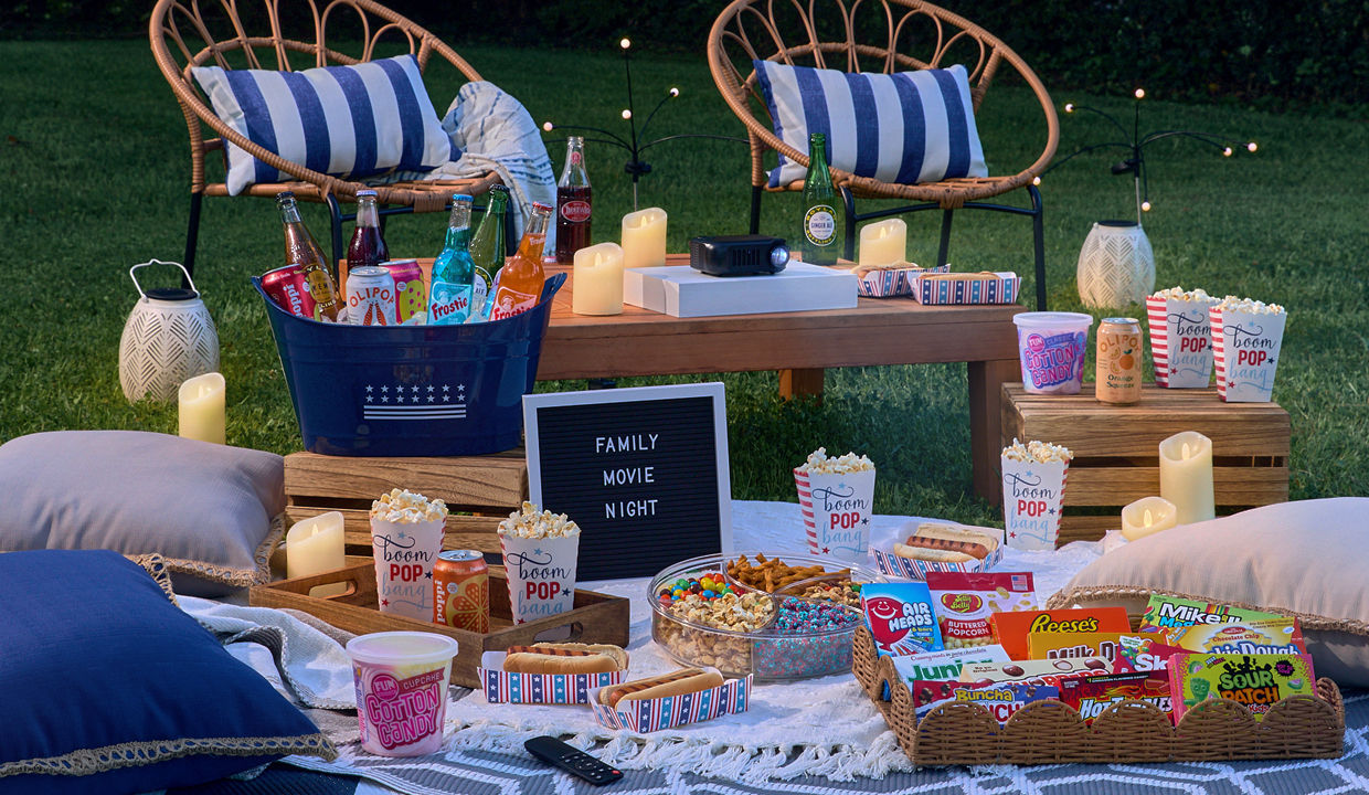 Backyard movie night with popcorns, theater boxed candy, drinks, blankets, pillows, rugs & more.