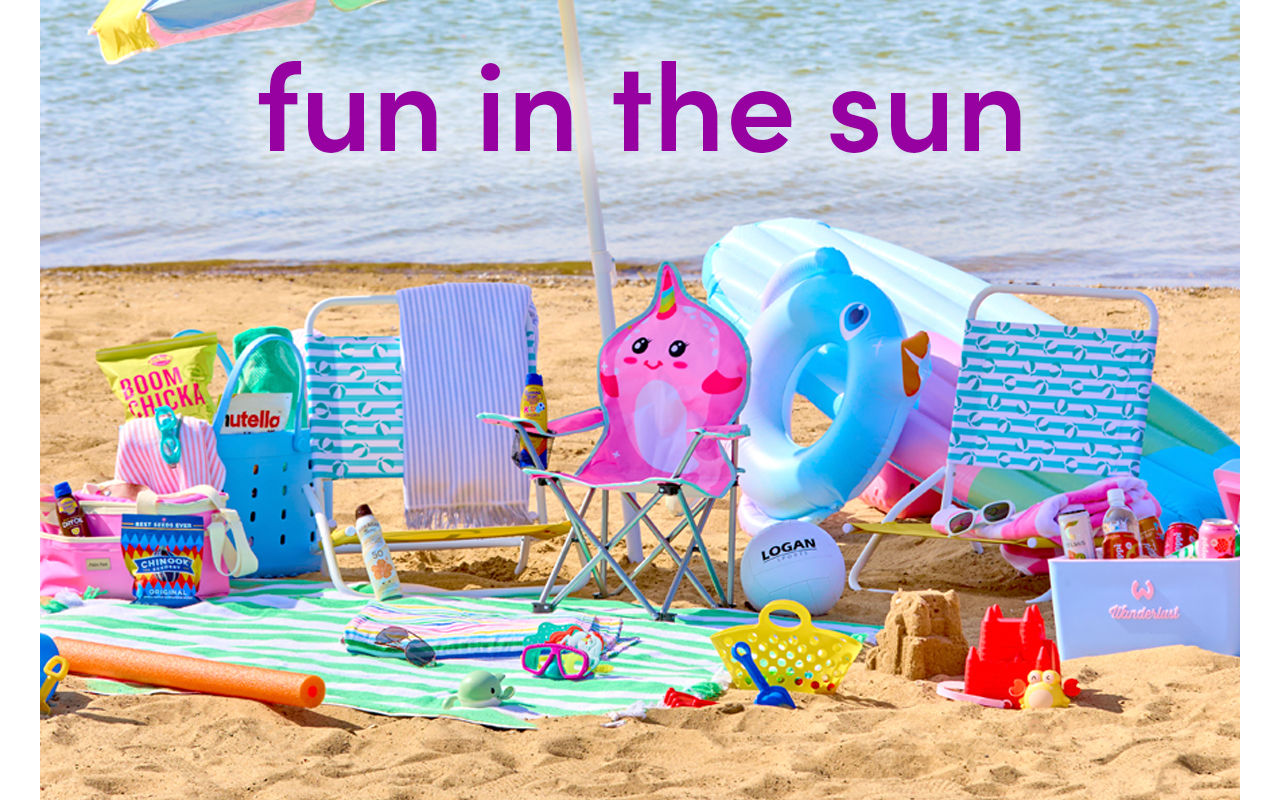 Beach scene with folding beach chairs, beach umbrella, beach towels, insulated coolers & sand toys.