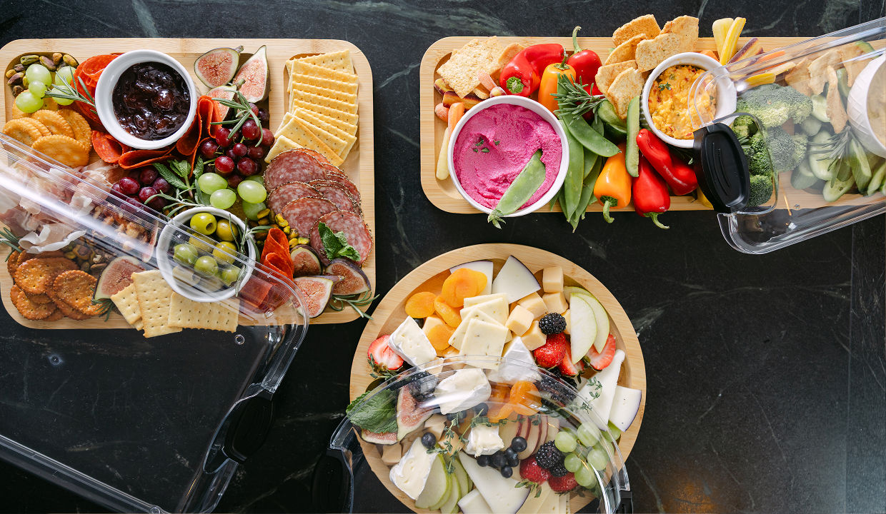 Several charcuterie boards in various shapes feature charcuterie snacks arranged among the boards.