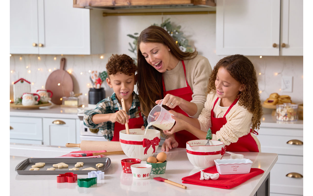 Family making cookies in a kitchen decorated with decor from pOpshelf and Christmas mixing bowls, cookies cutters, baking pans & more.