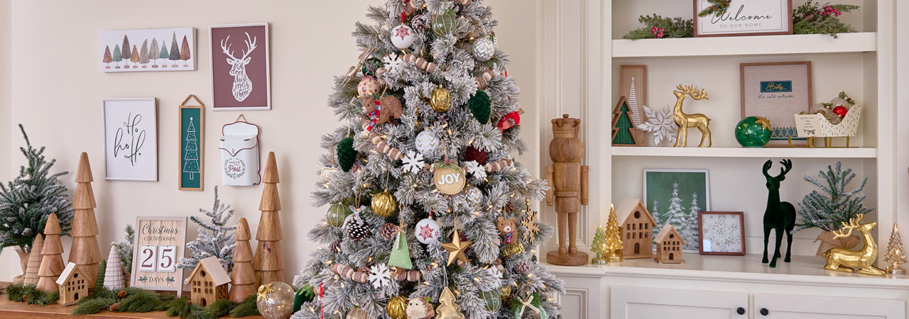 Room with Christmas tree decorated for Christmas in the Winter Woodlands collection with large solid-wood trees and nutcrackers, wooden garland, wooden village houses, and rustic and deer accents.