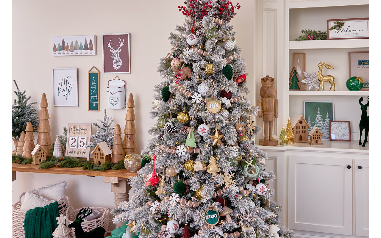 Room with Christmas tree decorated for Christmas in the Winter Woodlands collection with large solid-wood trees and nutcrackers, wooden garland, wooden village houses, and rustic and deer accents.