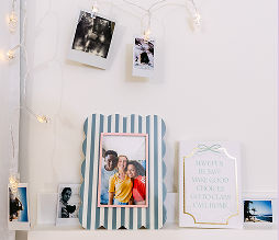 A striped picture frame and dorm room wall decor is featured in a dorm room.