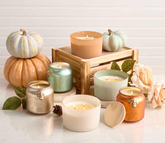 Collection of fall container and jar candles in various pastel colors, fall scents, and shapes.