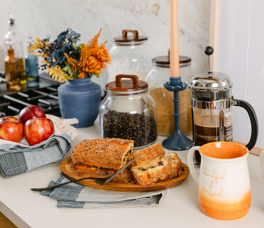 A neutral kitchen with a white granite wall features a close-up of a countertop space decorated with affordable fall-themed decor and kitchen essentials from pOpshelf.