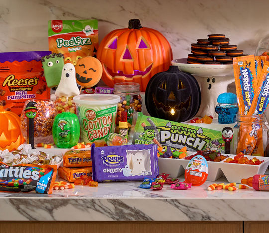 Various colorful Halloween candy and treats: marshmallow Peeps, gummy candy, decorated cookie and rice cereal treat pops, Reese's Pumpkins, candy corn & more.