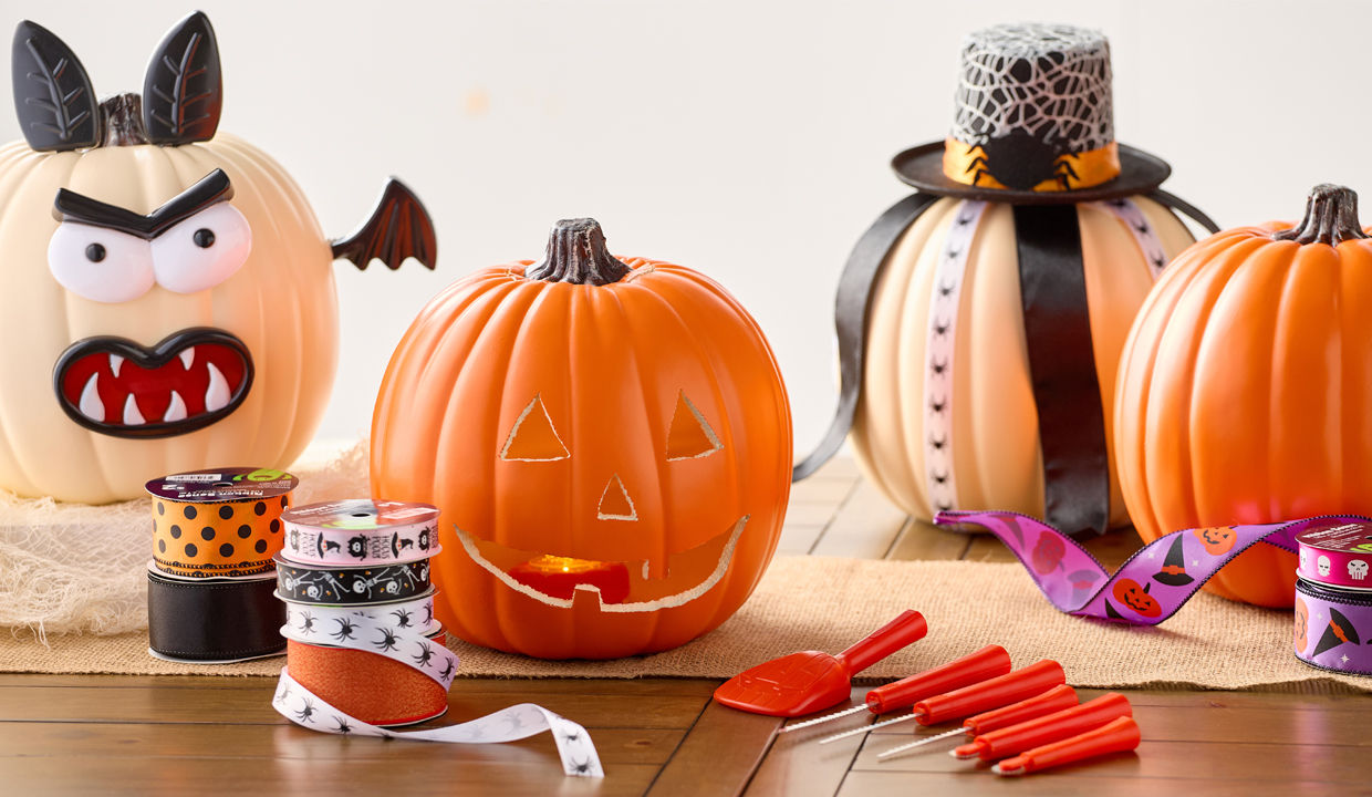 Wooden werewolf and jack-o-lantern paintable masks surrounded by paint tubes, paintbrushes, and pumpkins.  