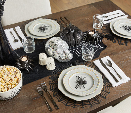 Halloween dining essentials: spider web placemats and table runner, ghost sale & pepper shakers, web serving bowl & more.