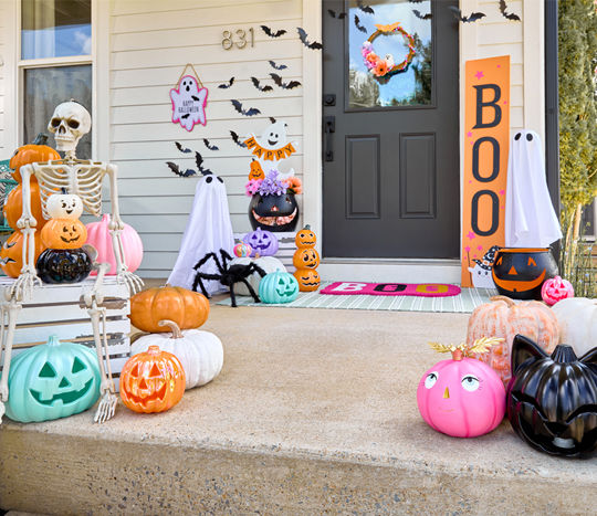Front porch decorated for Halloween with cute ghosts, jack-O-lanterns, and boo decor in bright and pastel colors.