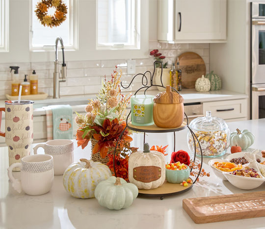 Kitchen with fall pumpkins, floral, and decor, fall mugs, tumblers, pumpkin canister, ramekins, divided serving plate & other kitchen serveware.