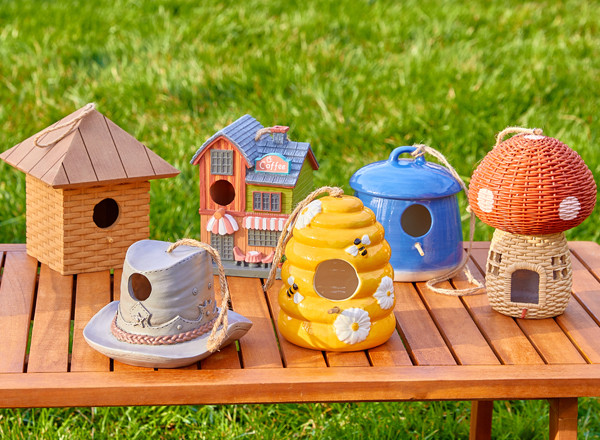 Row of birdhouses in various shapes & designs: cowboy hat, bee hive, mushroom, coffee shop, and more.