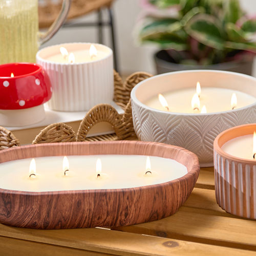 Citronella candles from pOpshelf in various sizes and designs on a wooden table.