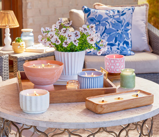 Various citronella candles on outdoor table in patio setting