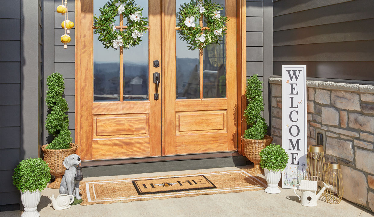 Front porch decorated with garden & patio décor from pOpshelf: lanterns, porch leaner, wreaths, potted topiaries, coir welcome mat, lanterns & more.