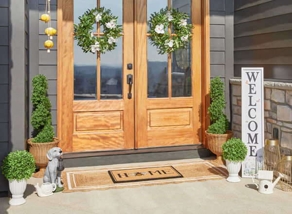 Front porch decorated with garden & patio décor from pOpshelf: lanterns, porch leaner, wreaths, potted topiaries, coir welcome mat, lanterns & more.