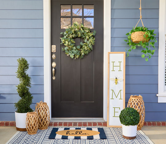 Front porch decorated with garden & patio décor from pOpshelf: lanterns, porch leaner, potted plants, topiaries, hanging planter & more.