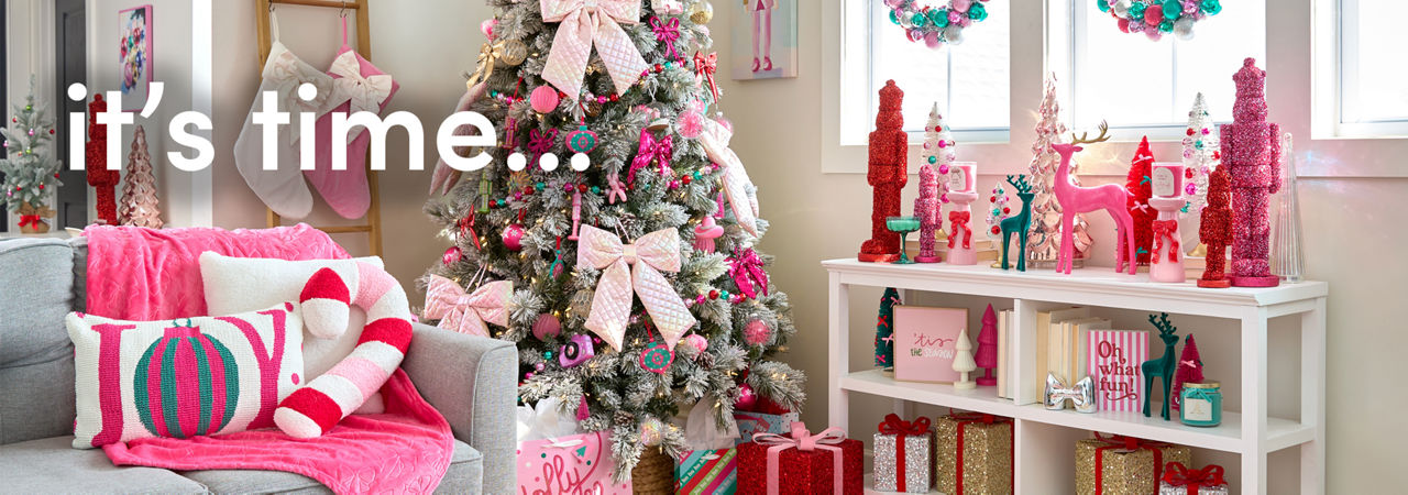 Room decorated with the Merry Merry pink, bows, and sparkly decor collection from pOpshelf: tree ornaments, wall art, pillows, throws, tinsel nutcrackers, bottlebrush trees, candles, ornament wreaths & garland.