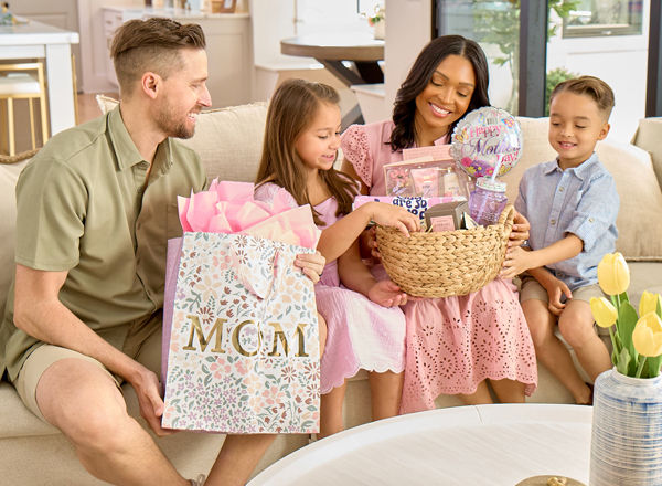 Mother, father, and kids giving mom Mother's Day gifts from pOpshelf.