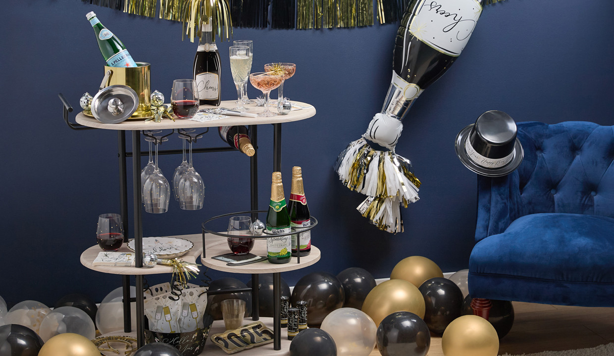 New Year's Eve Bar Cart and Party Supplies from pOpshelf: giant champagne foil balloon, top hats, balloons, gold confetti wine glasses, dublin champagne glasses, and more.