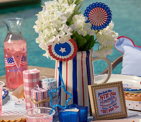 A poolside table is decorated with patriotic red, white & blue decor.