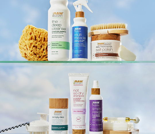 Bathroom shelves with products from Raw Sugar and decorated with different bath essentials like a scrub brush and sponge.
