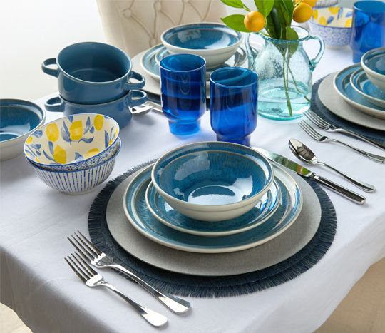 Table set with blue reflective dinnerware.