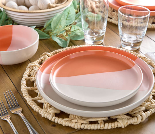 Table set with salmon and white ombre dinnerware.