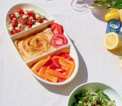A close-up shot of a three-part serving platter from pOpshelf filled with savory summer snacks.