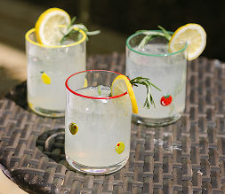Cute icon glassware filled with lemonade sitting on a white backyard table.