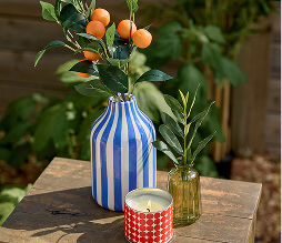 A small striped ceramic vase decorated with citrus springs.