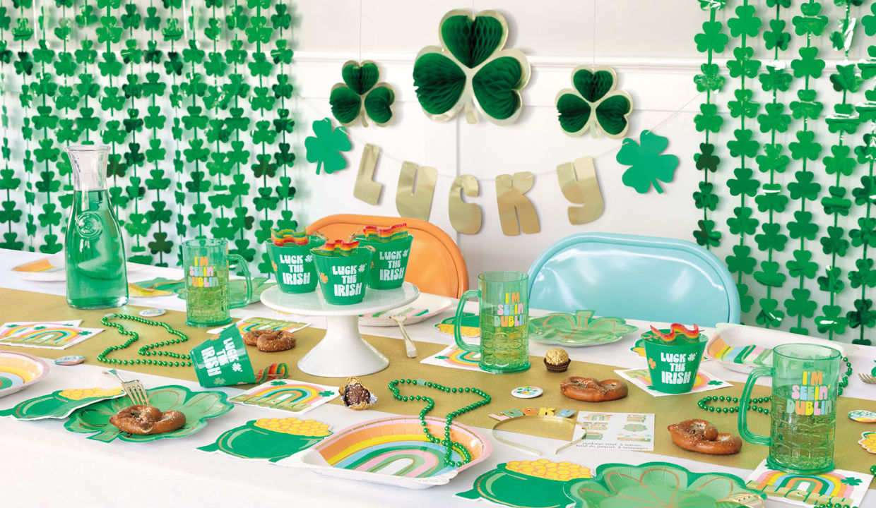 St. Patrick's Day party items: rainbow & shamrock plates, pot of gold & rainbow napkins, green party cups & mugs, necklaces, wall decorations & more.