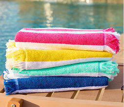 Colorful pool towels hanging from hooks in various patterns and prints