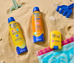 Three variations of sunscreen from pOpshelf displayed in the sand.