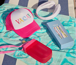 Pool day essentials like a ball cap, water bottle, headphones, and summer games displayed on a pool towel.