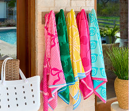 Soft multi-colored pool towels hanging poolside.