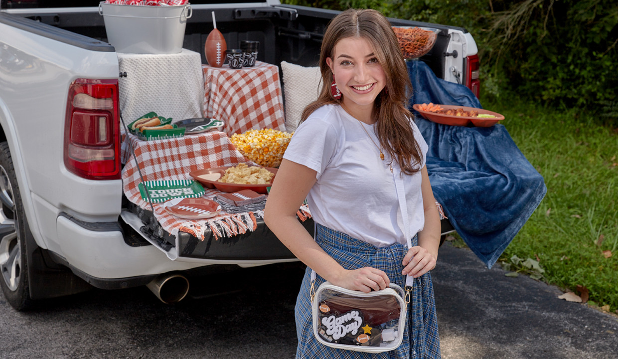 Girl at tailgating party with football-themed party supplies, clear cross-body bag with game sticker patches, and football-themed jewelry and face stickers.