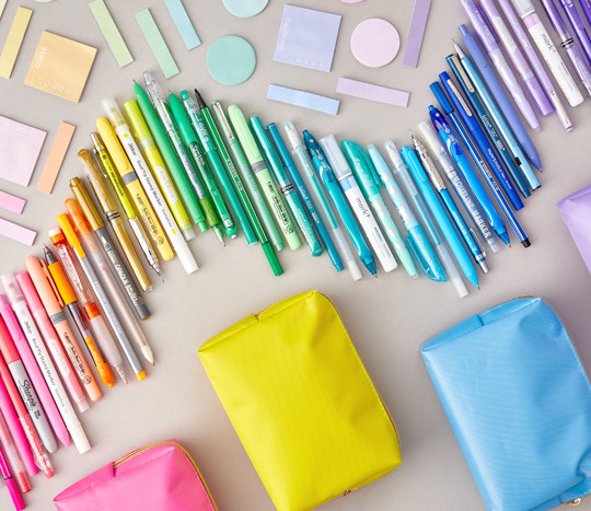 Pens, markers, and highlighters in a rainbow of colors with sticky notes and pencil pouches.