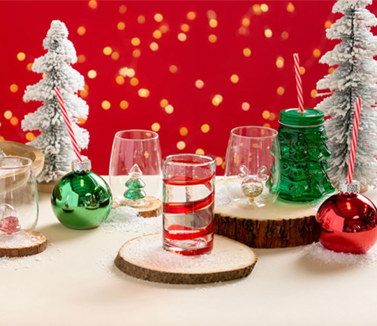 Red swirl glasses, glass ornament and tree sippers, and stemless wine glasses with festiven designs in the bottom