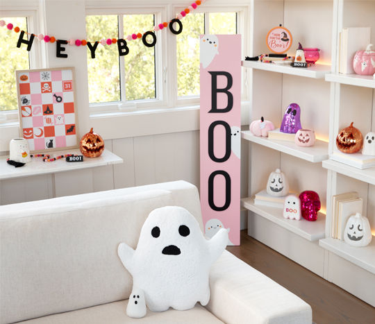 Pastel-themed halloween decor: Boo pouch leaner, ghost pillow, pink checkered sign, pink and silver jack-o-lanterns, sparkly skulls & more.