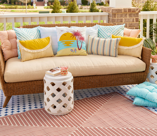 Patio sofa with multiple indoor/outdoor pillows in various sizes, colors, and designs from pOpshelf.