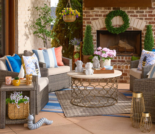 Back patio decorated with rugs, pillows, spring floral, decor, lanterns, candles and more.