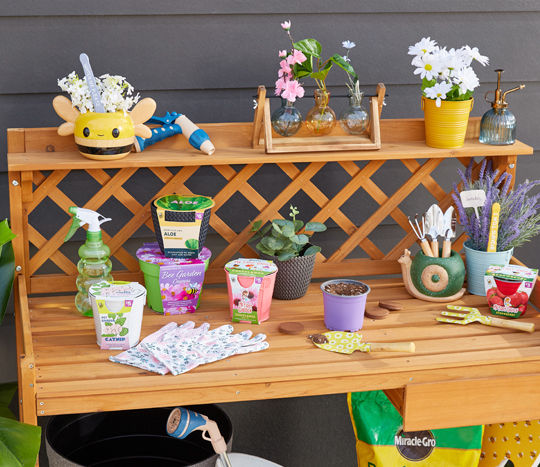 Potting bench with gardening tools, potting soil, glass water mister, garden pots, and gardening seeds, bulbs, and grow kits from pOpshelf.