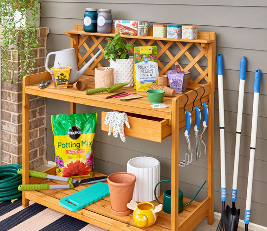 Potting bench with gardening tools, potting soil, watering can, garden pots, and gardening seeds, bulbs, and grow kits from pOpshelf.