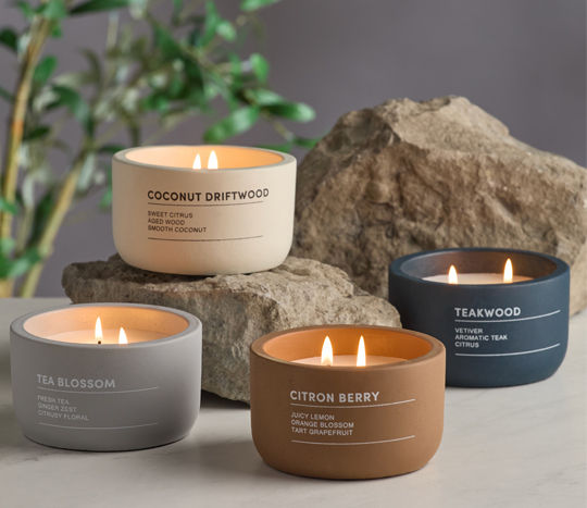 cement candles lit surrounded but rocks and greenery