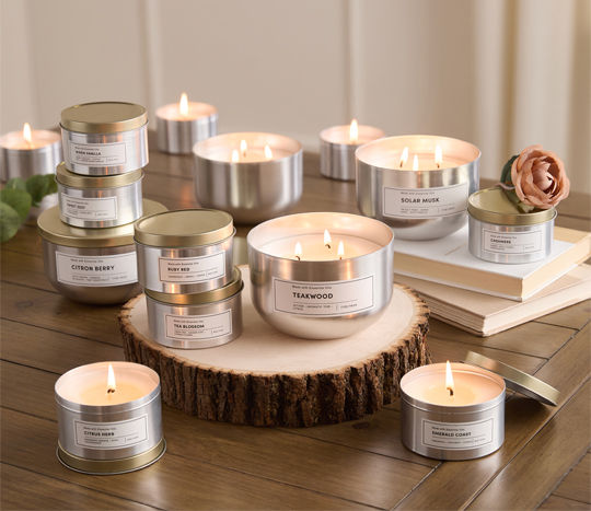 tin candles lit on wooden tree stump and dried flowers