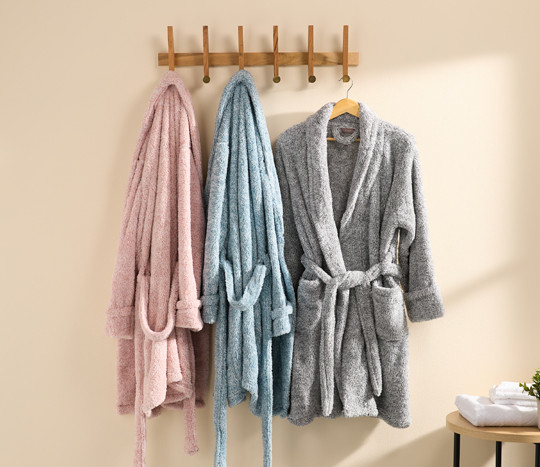 Women's plush shearling robes hanging on hooks: pink, blue & gray robes