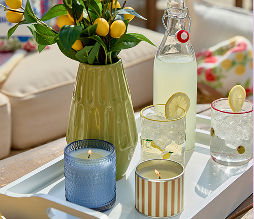 Affordable glass candles featuring various designs including stripes and solid summer colors.