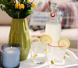 Cute decorative glassware filled with lemonade sitting on a white serving tray.