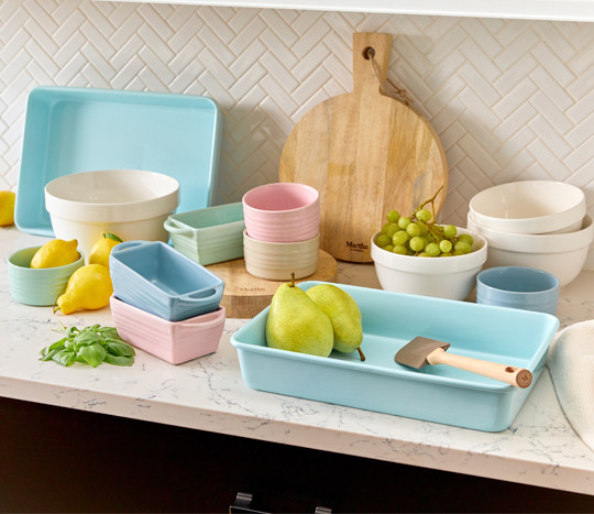 Pastel colored Martha Stewart loaf pans, sheet pans, small bowls, and more for baking.